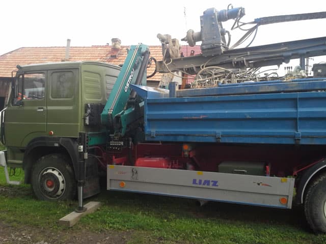 Nákladné auto s hydraulickou rukou a vrtnou technikou